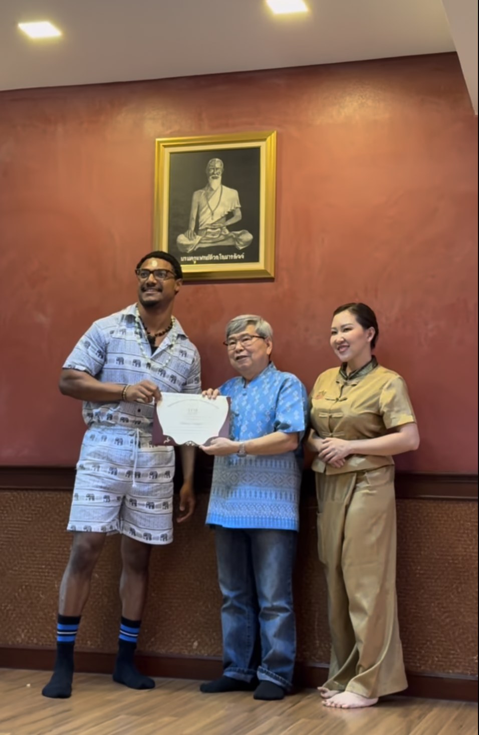 Elijah Naylor Jr. receiving a certificate during Thai medicine training