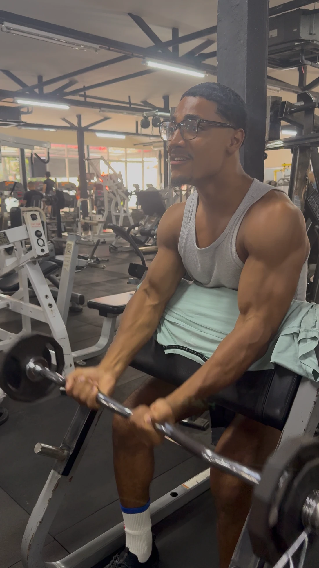 Elijah performing a preacher curl in the gym