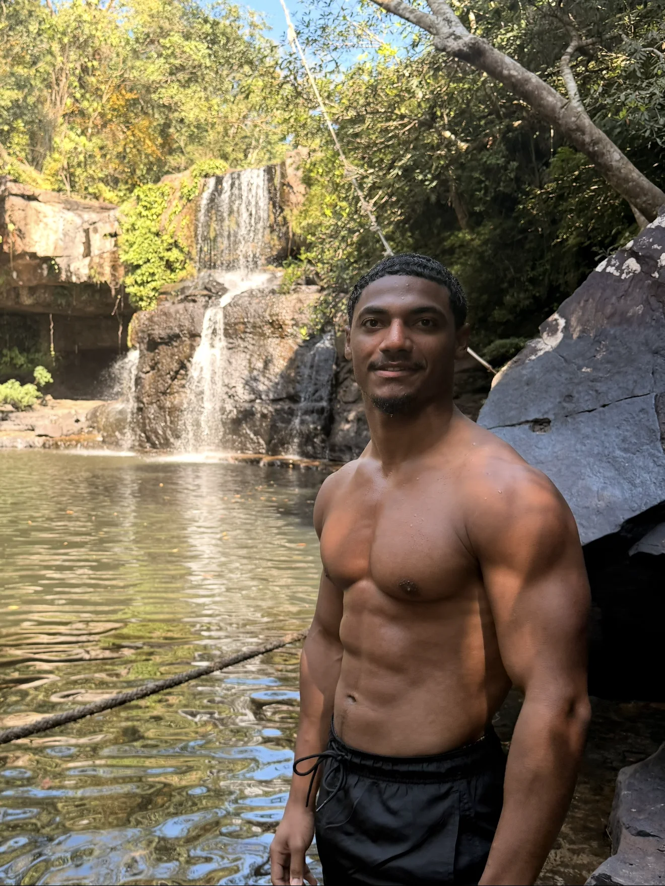 Elijah Naylor standing beside a waterfall